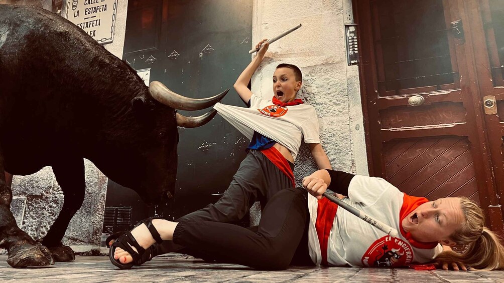 A bullfight scene with a bull and a person lying on the ground. 4
