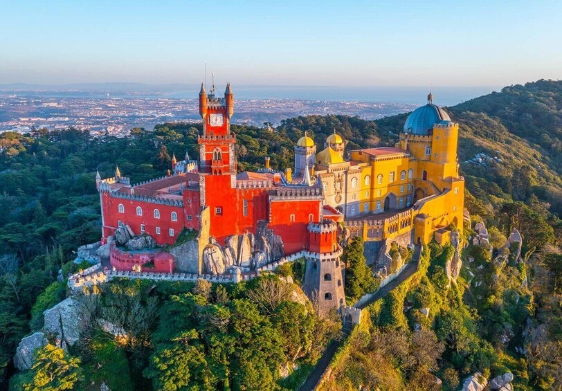 Pena Palace, a historic castle in Sintra, Portugal, surrounded by lush greenery and perched on a hill overlooking the city. 5