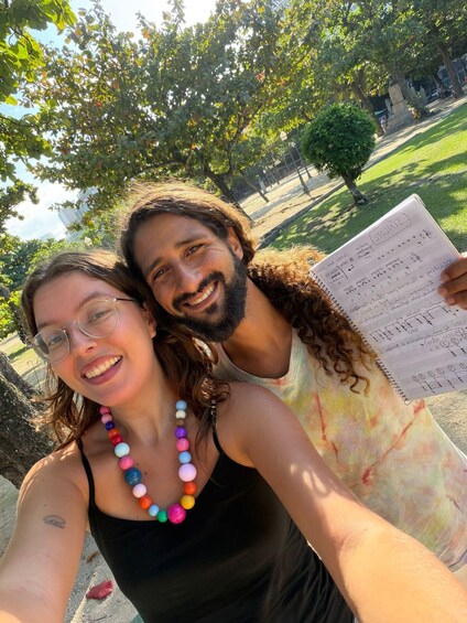 Two people taking a selfie with a musical score in the foreground. 2