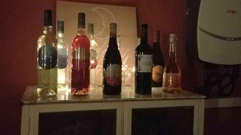 A collection of wine bottles on a cabinet. 1