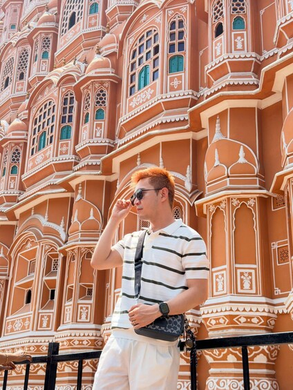 A person standing in front of a building with intricate architectural details. 4