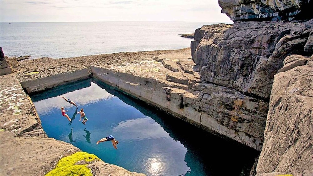 A natural swimming pool surrounded by rocky cliffs. 5