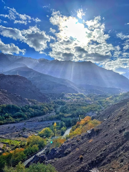 A mountainous landscape with a river, greenery, and a clear sky. 5
