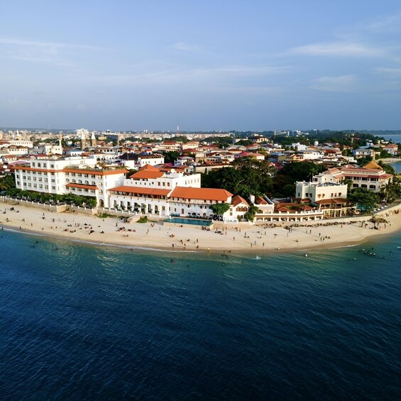 An aerial view of a coastal city with a beach, buildings, and a clear sky. 1