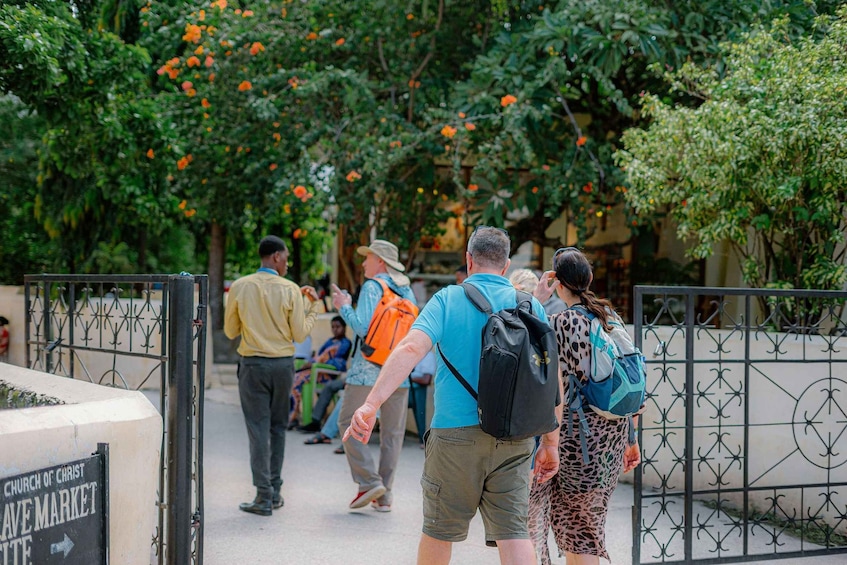 A group of people walking along a path with a sign for the Church of Christ Live Market. 3