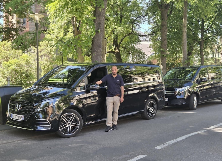 A black Mercedes-Benz SUV parked on a tree-lined street. 1