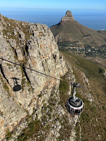 A cable car system on a rocky mountain with a town in the background. 4