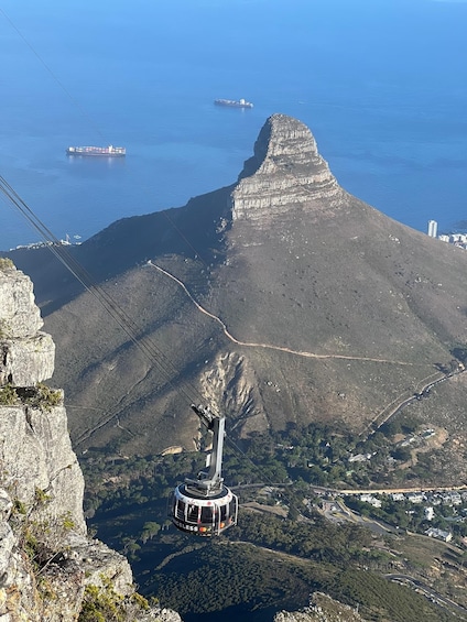 A cable car system, a mountain peak, and a body of water with ships. 2