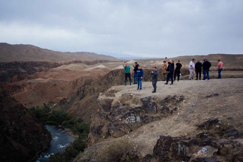 A group of people standing on a rocky outcrop overlooking a river valley. 2