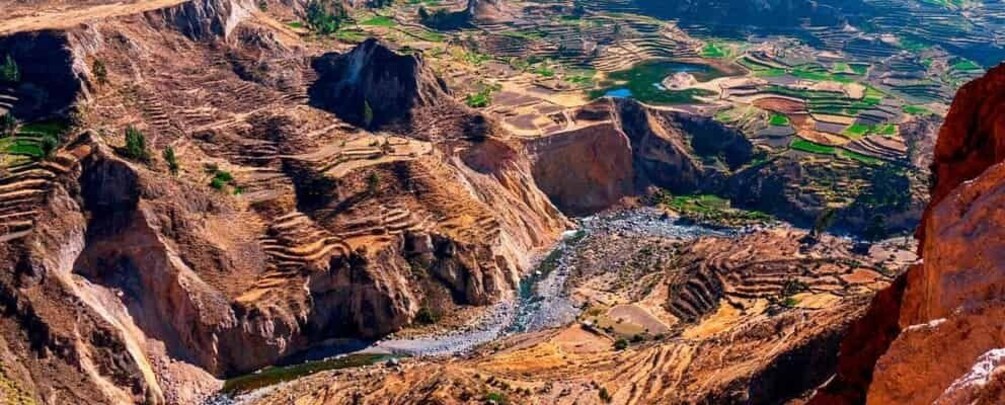Een terrasvormig landschap met een rivier die door een kloof stroomt. 4