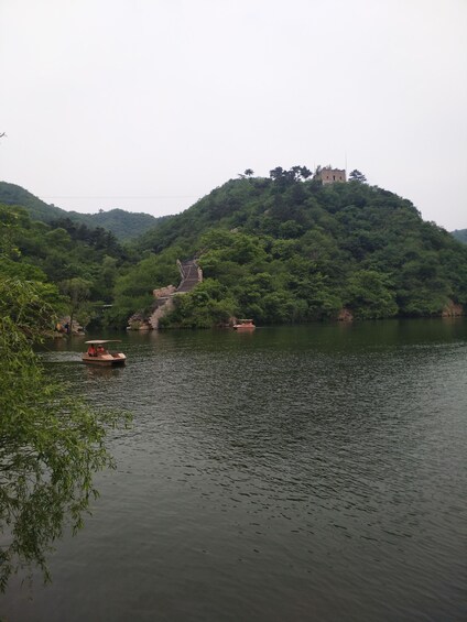 A river with a boat and a bridge on a hill. 2