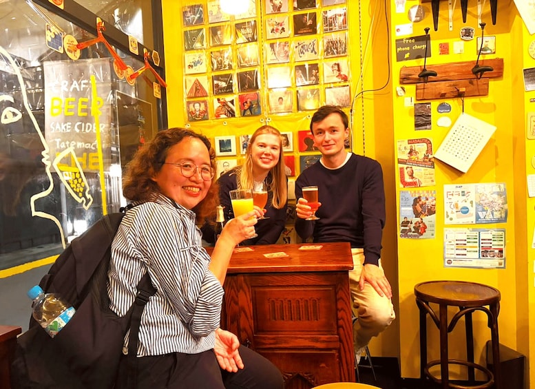 A group of people sitting at a bar with a yellow wall decorated with movie posters. 1