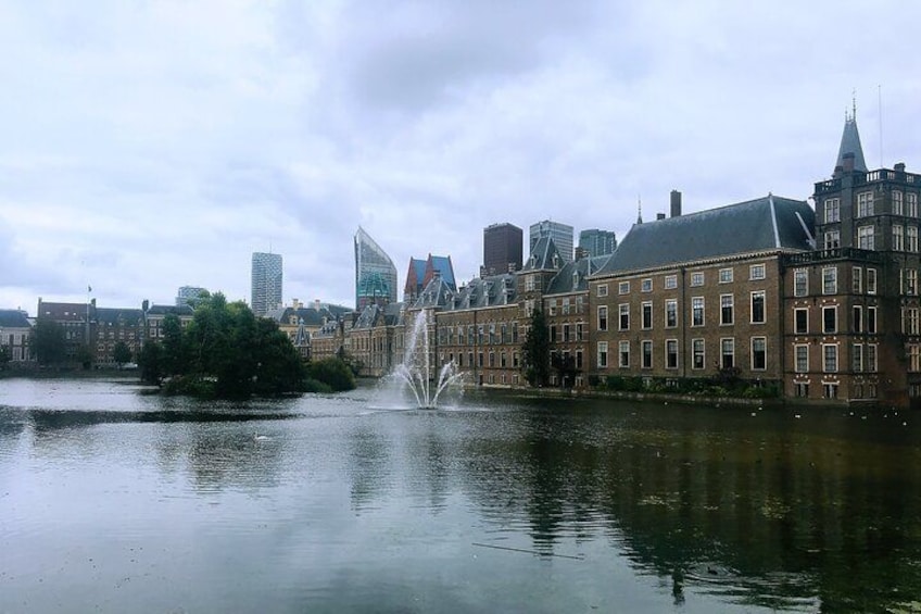 A cityscape with a river, a fountain, and historic buildings. 2