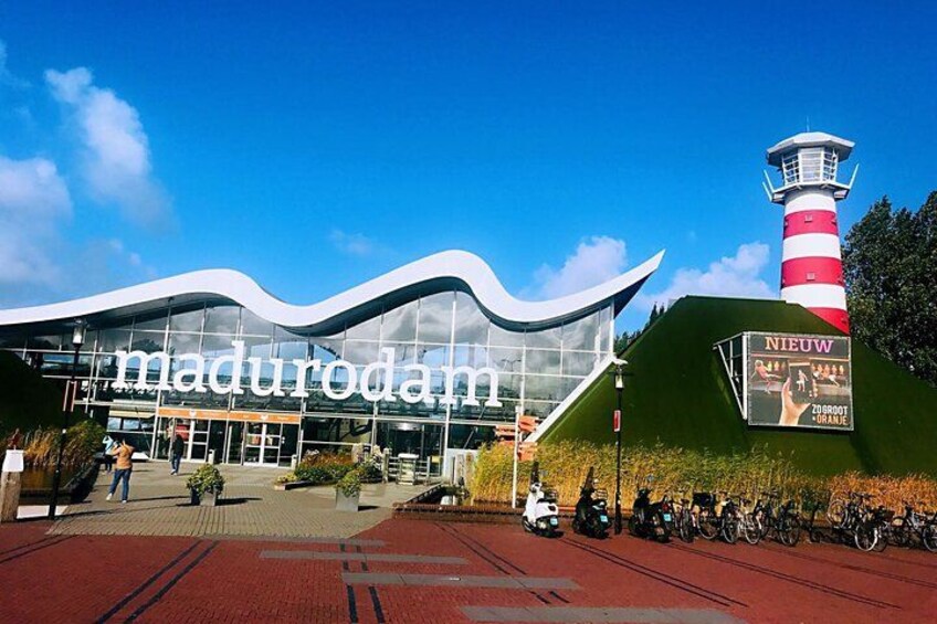 A modern building with the name 'madurodam' and a lighthouse in the background. 4