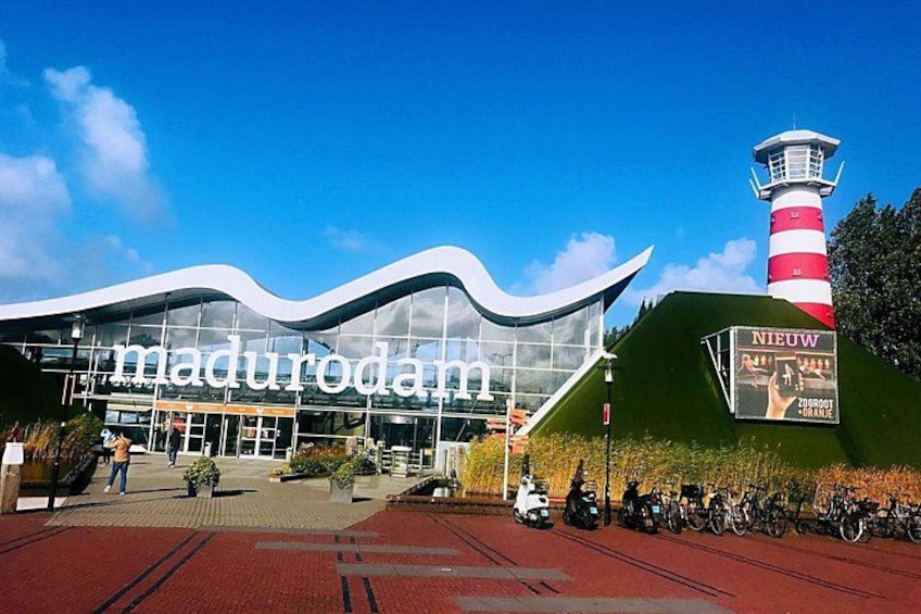 Ein modernes Gebäude mit dem Schild 'Madurodam' und einem Leuchtturm im Hintergrund. 4
