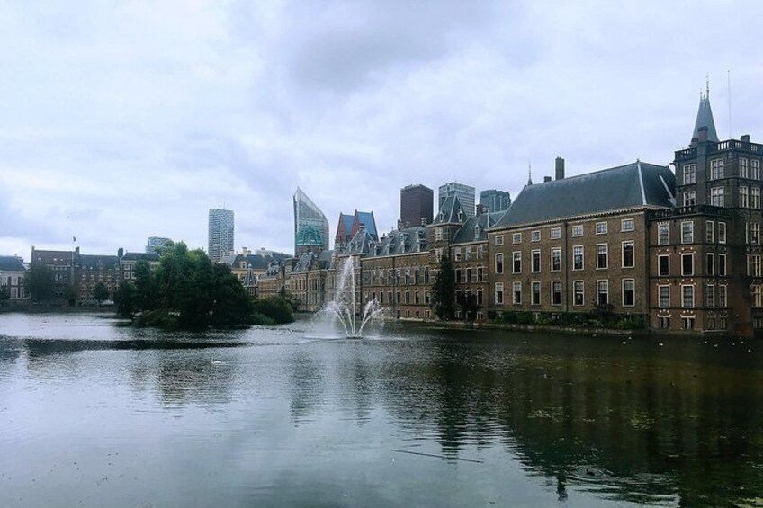 A cityscape with a river, a fountain, and historic buildings. 2