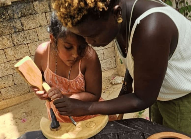 A person using a wooden tool on a circular object. 5