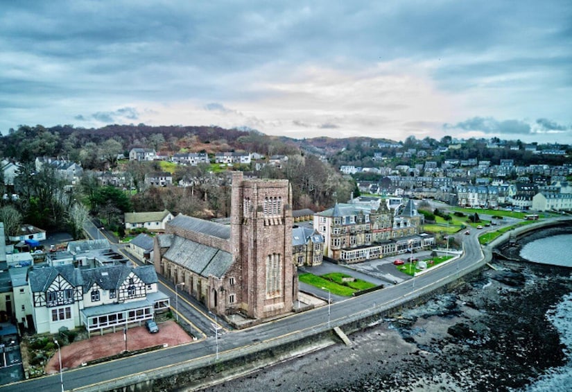 A coastal town with a prominent church, a roundabout, and residential buildings. 5