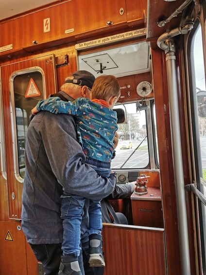 A man and a child in a train carriage, with the man holding the child. 3