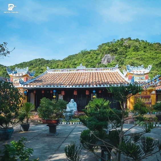 A traditional Chinese temple with ornate roofs and a statue in the courtyard. 2