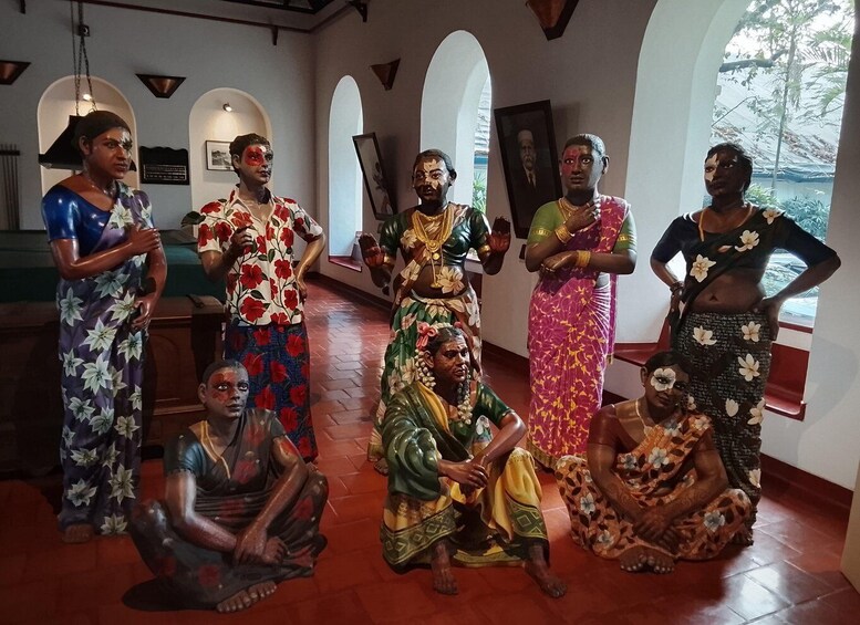 A group of people in traditional attire in an indoor setting with arched ceilings and wooden floors. 2
