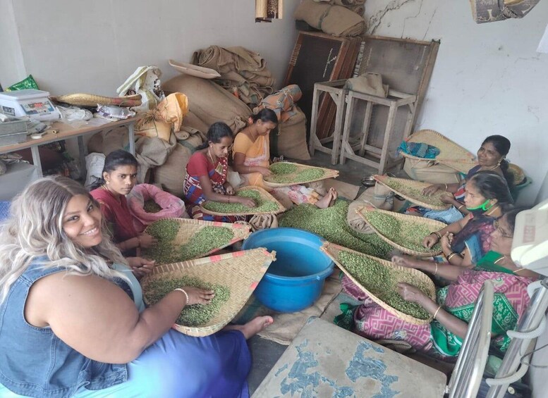 A group of women sorting green beans in a rustic setting with sacks and baskets. 5