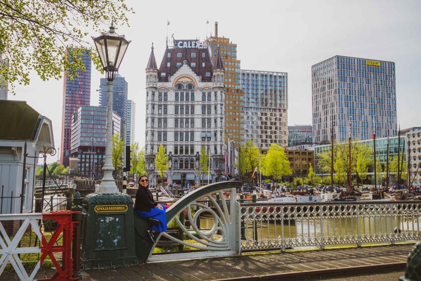 A person sitting on a bridge with a cityscape in the background. 2