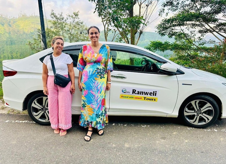Two people standing beside a white car with a 'Ranwel Tours' sign. 4