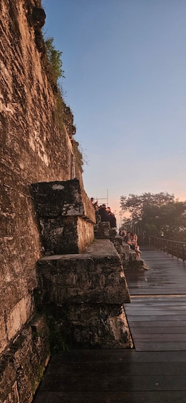 A stone staircase leading down to a wooden deck by a body of water. 3