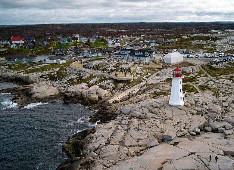 A coastal town with a prominent white lighthouse, rocky shoreline, and a mix of residential buildings. 3