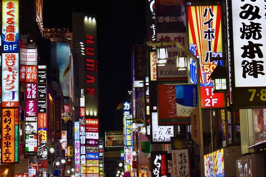 A busy urban street at night with numerous illuminated signs and billboards in a foreign language. 3