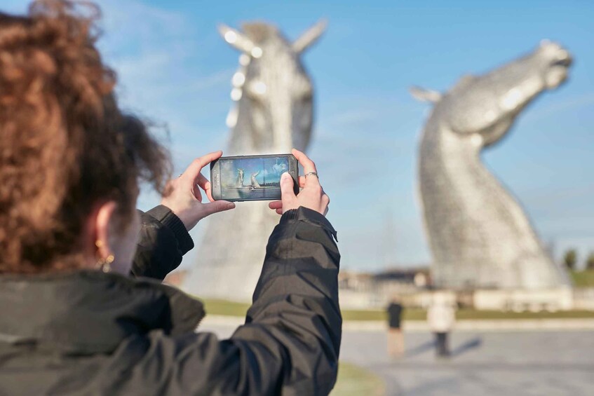 A person taking a photo of the Kelpies wind turbines. 1