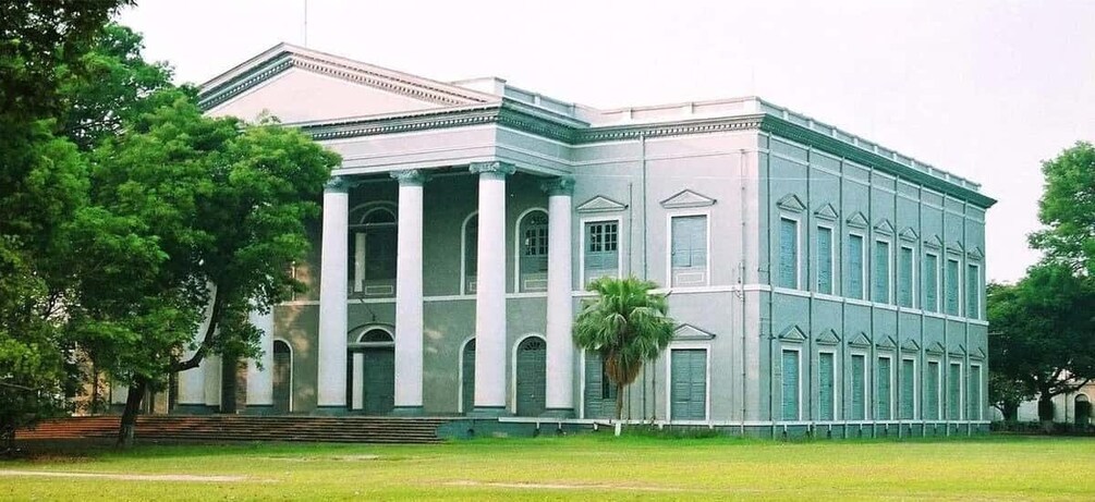 A large, historic building with a symmetrical facade, columns, and a central entrance. 5