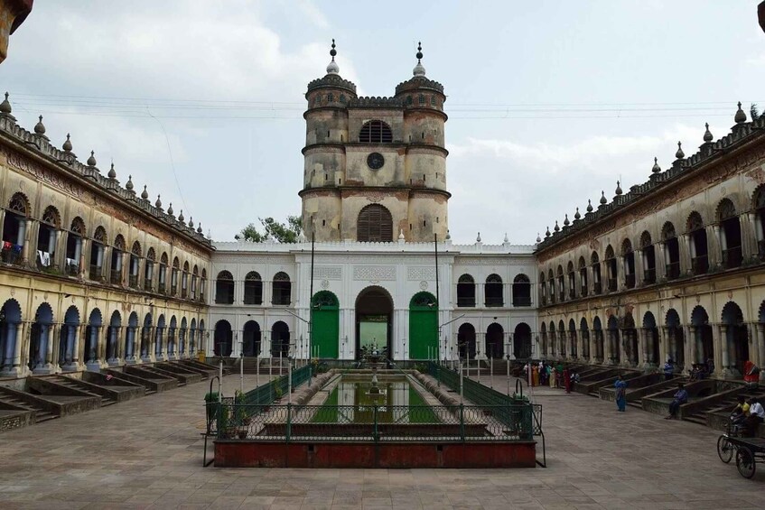 A historic building with a central courtyard, a fountain, and a clock tower. 1