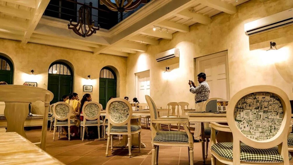 A restaurant interior with wooden chairs, tables, and a chandelier. 3