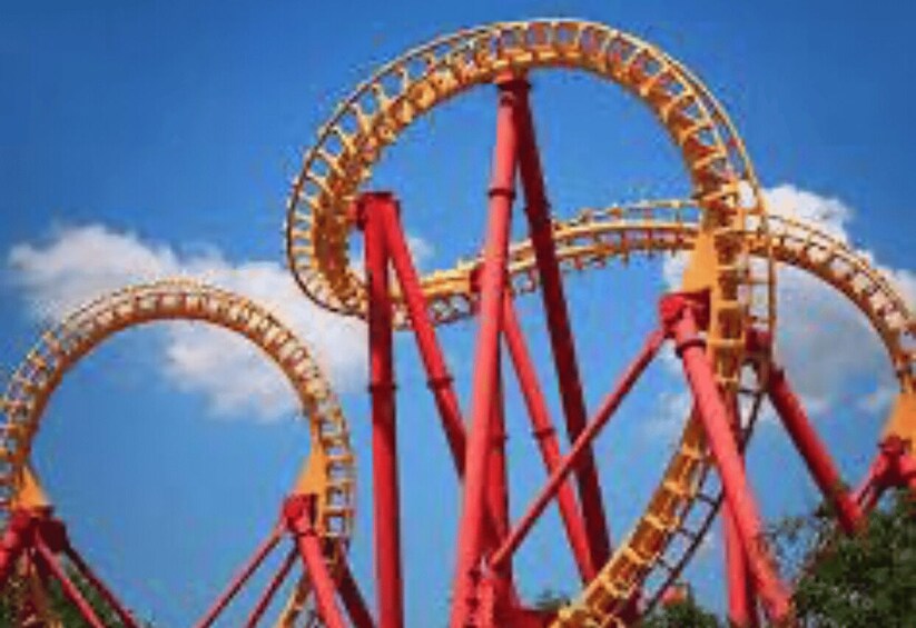 A roller coaster with red and yellow tracks against a blue sky. 2