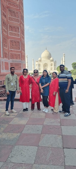 A group of people standing in front of the Taj Mahal. 1