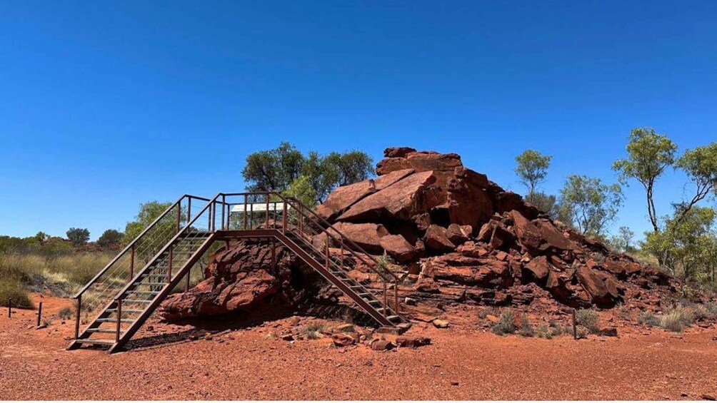 A red rock formation with a metal staircase leading up to a viewing platform. 2