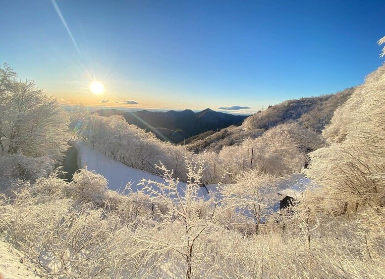 A snow-covered landscape with a river, mountains, and a clear sky. 5