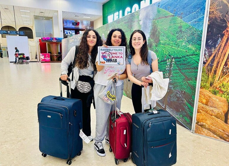 Three people with luggage in an airport, holding a sign for Ranwel Tours. 2