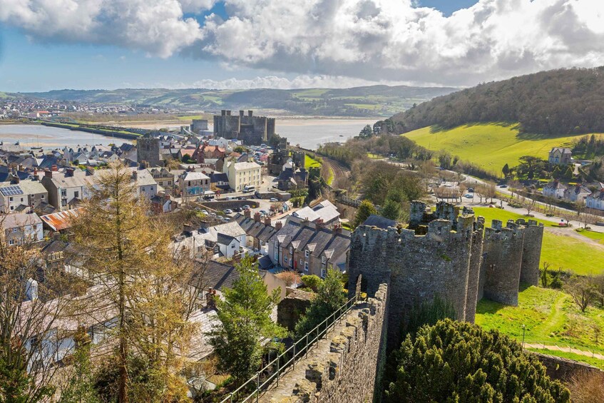 A town with a castle, a river, and rolling hills in the background. 3