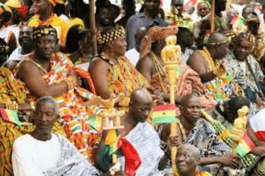 A group of people in traditional attire, some holding ceremonial objects. 3
