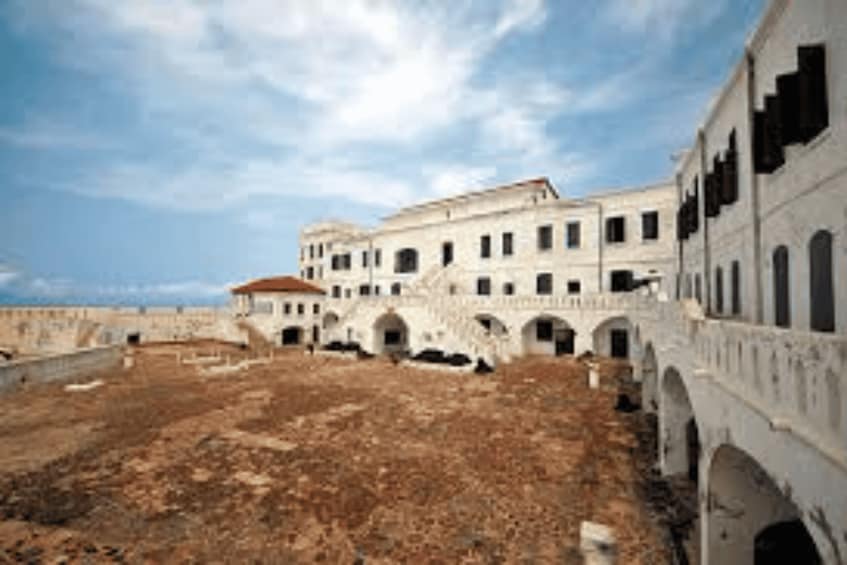 A large, historic building with multiple arches and a courtyard. 1