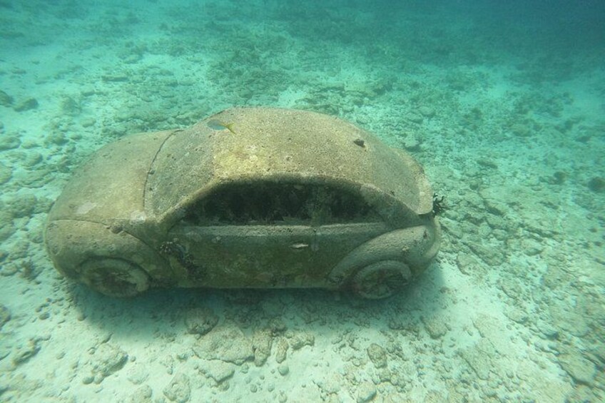 A submerged car on a sandy ocean floor. 2
