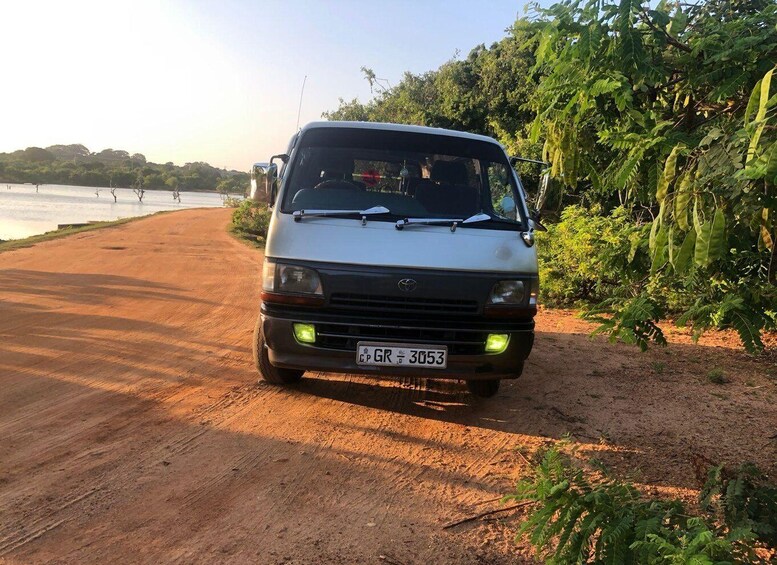 A white van parked on a dirt road with a license plate CP GR 3053. 3