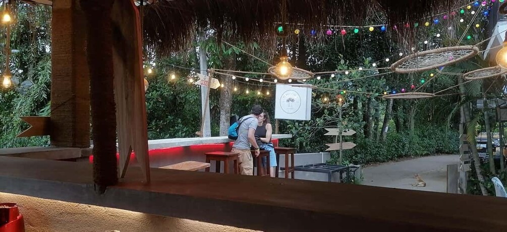 An outdoor seating area with string lights and a signboard. 5