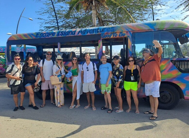 A group of people posing in front of a colorful bus with 'Escape Island Adventures' written on it. 5