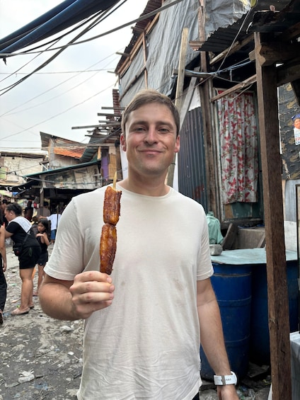 A person holding a long, grilled food item. 2