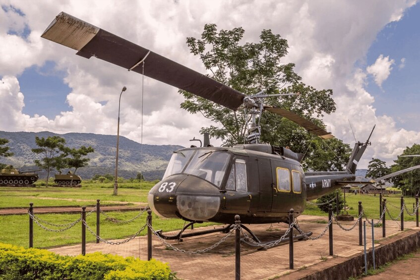 A military helicopter with the number 83 parked on a display with chains. 5
