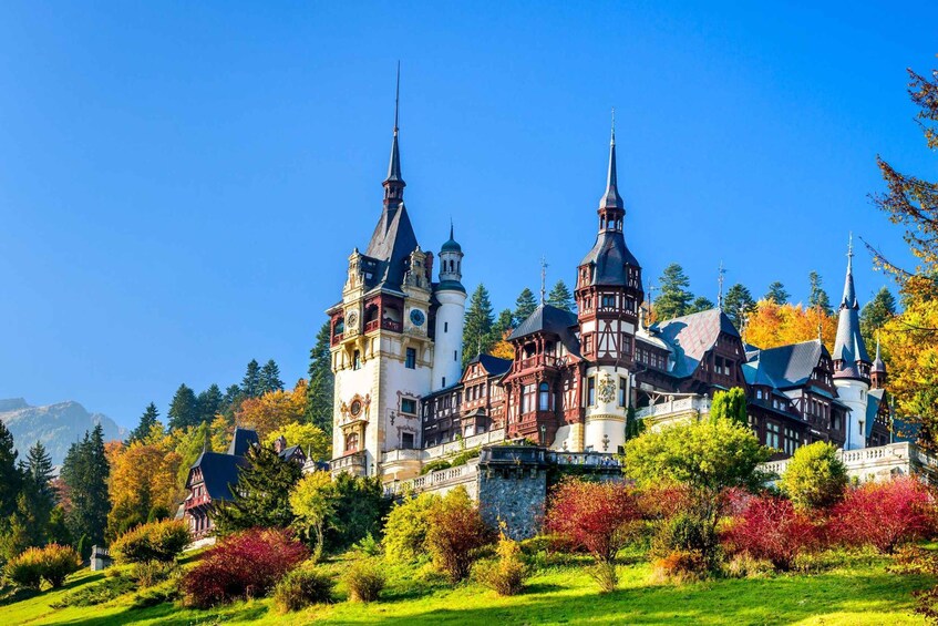 A historic castle with multiple towers and a lush garden. 1